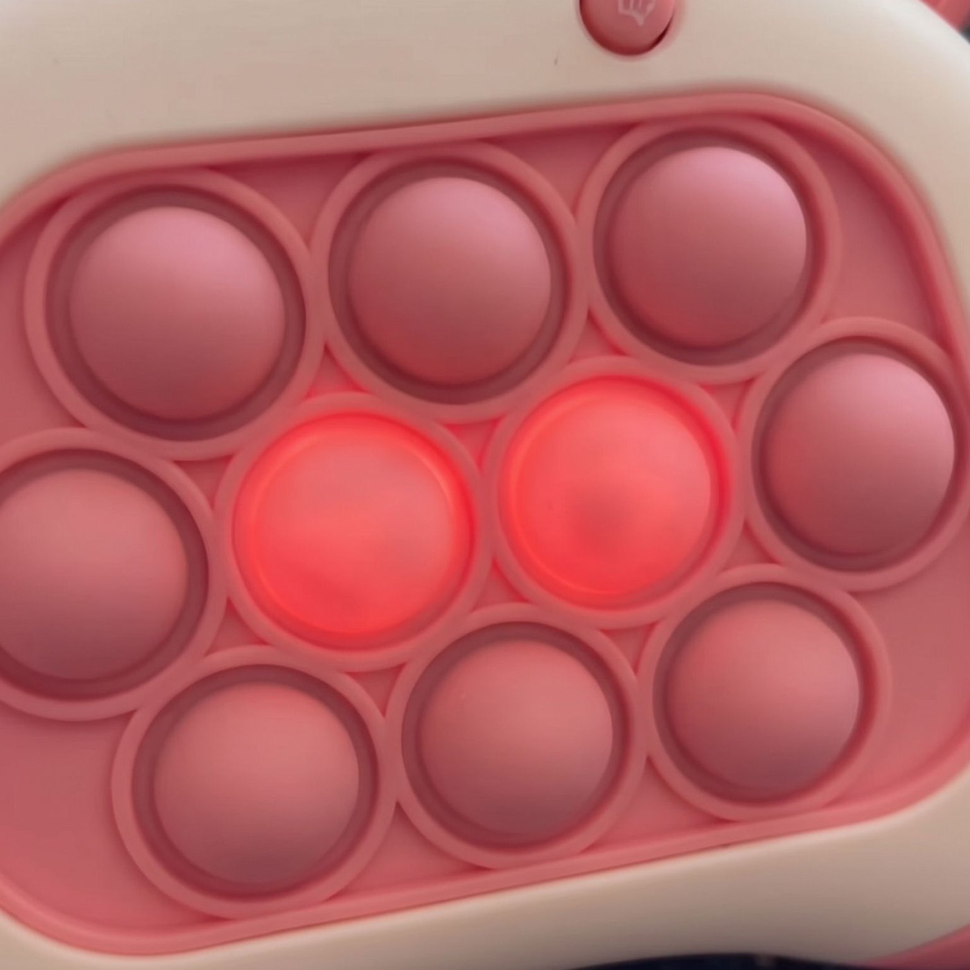 Close-up of lit bubbles on the pink push game