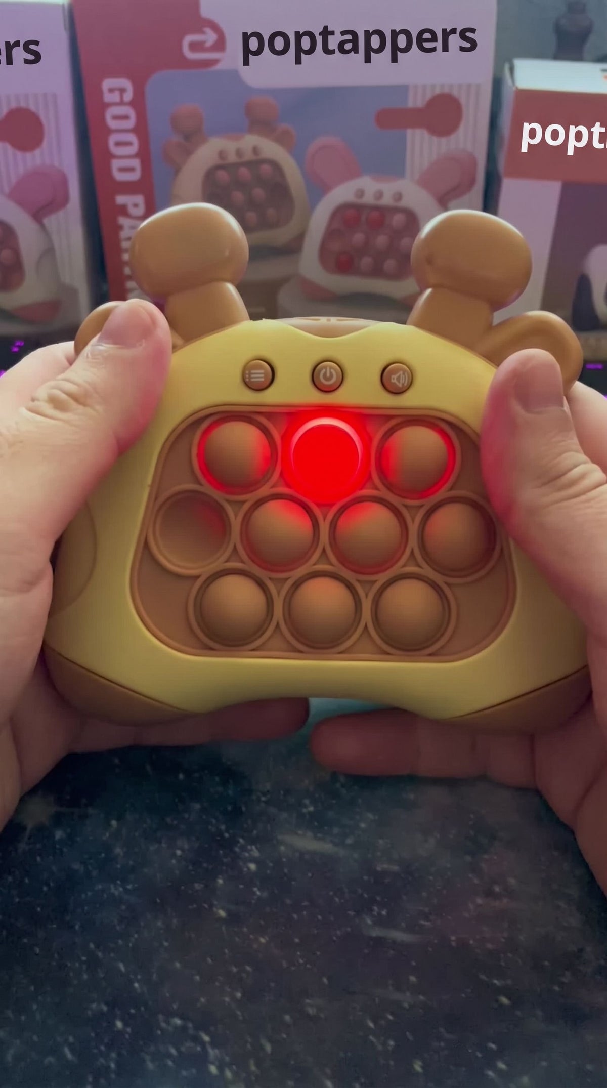 A grown-up's hands holding the brown giraffe push game with a lit bubble