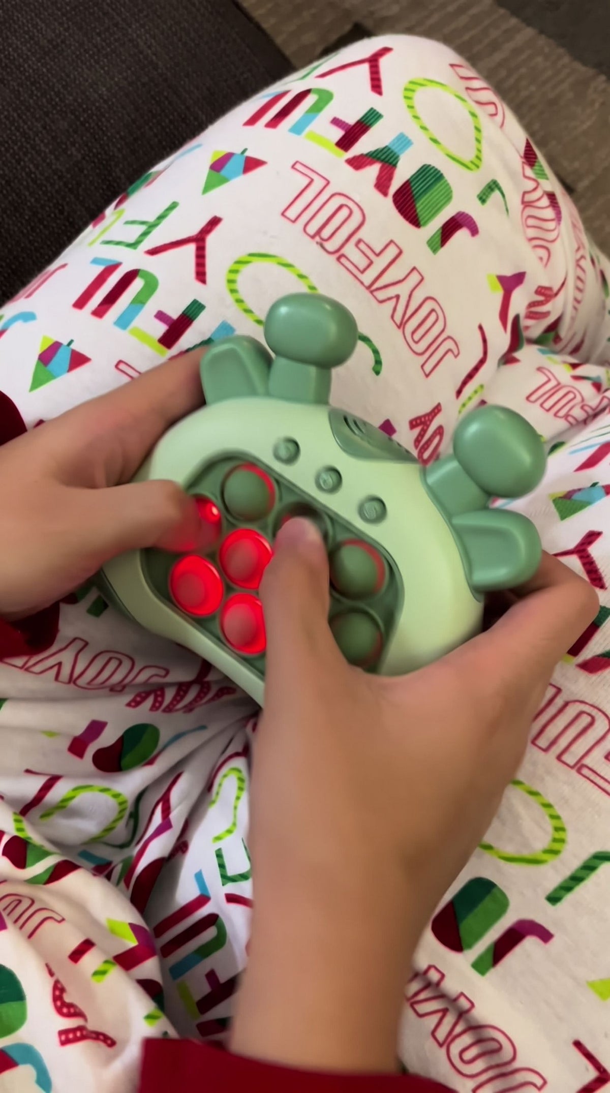 Hands pressing lit bubbles on the green giraffe push game