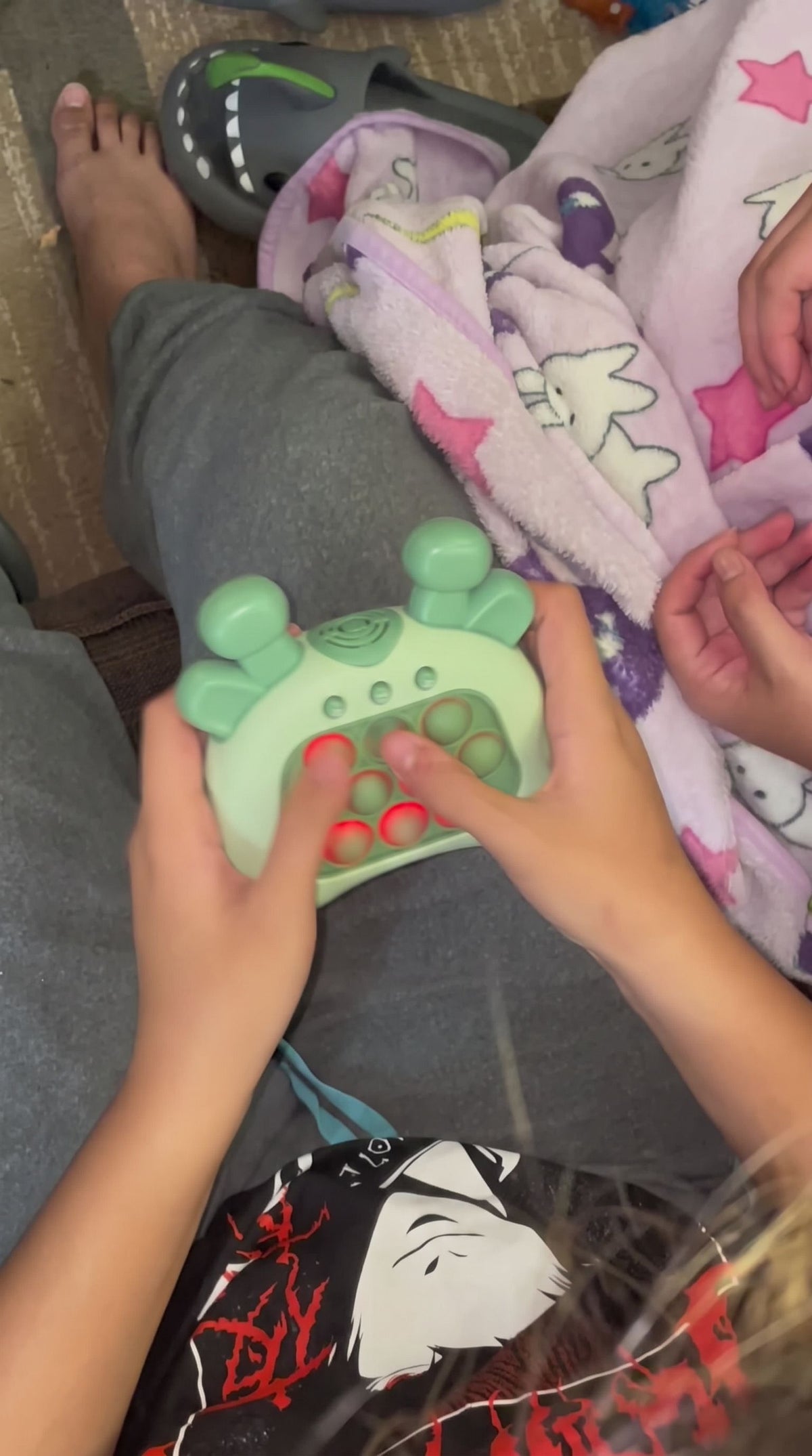 Two pairs of hands around the green giraffe push game