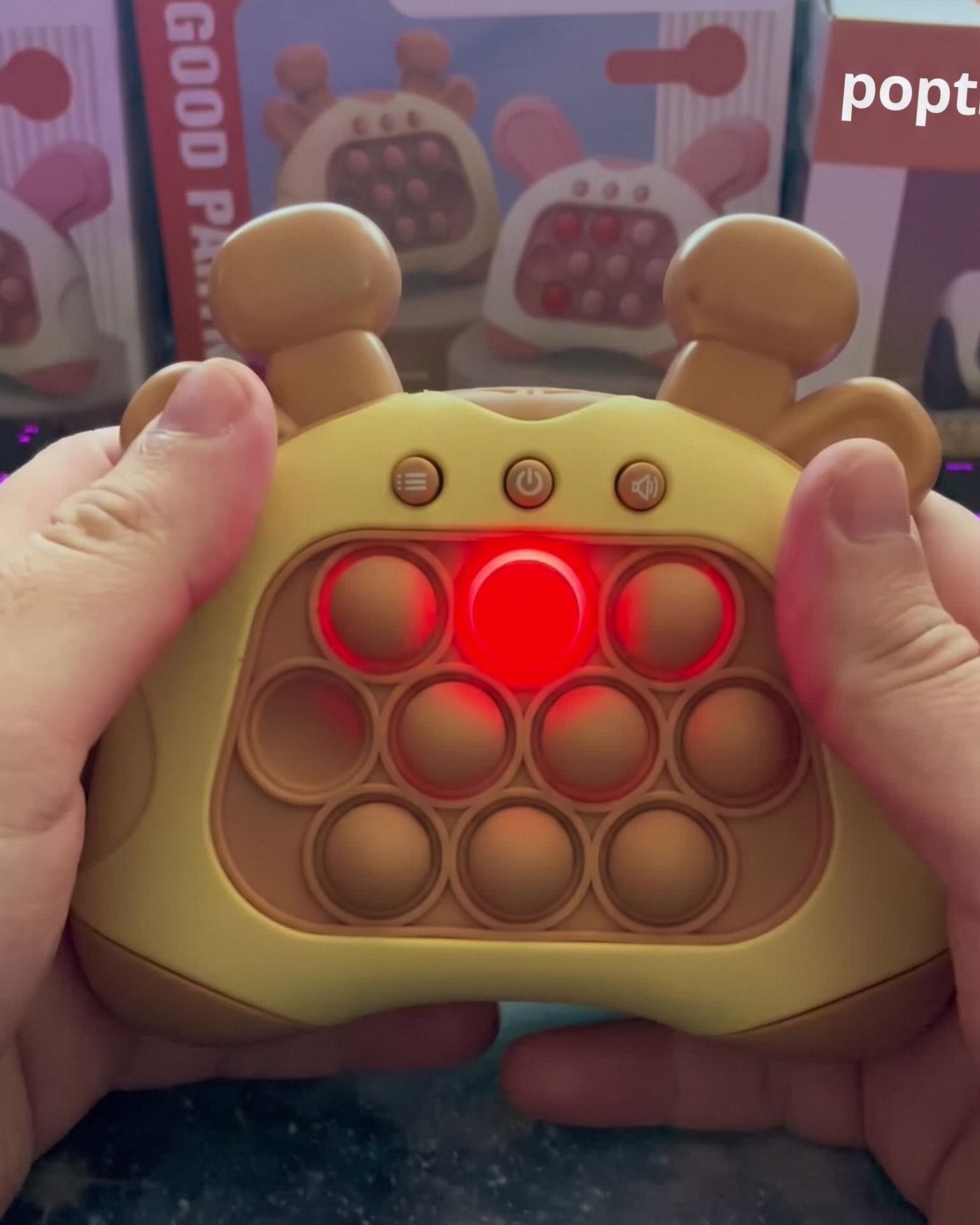 A grown-up's hands holding the brown giraffe push game with a lit bubble