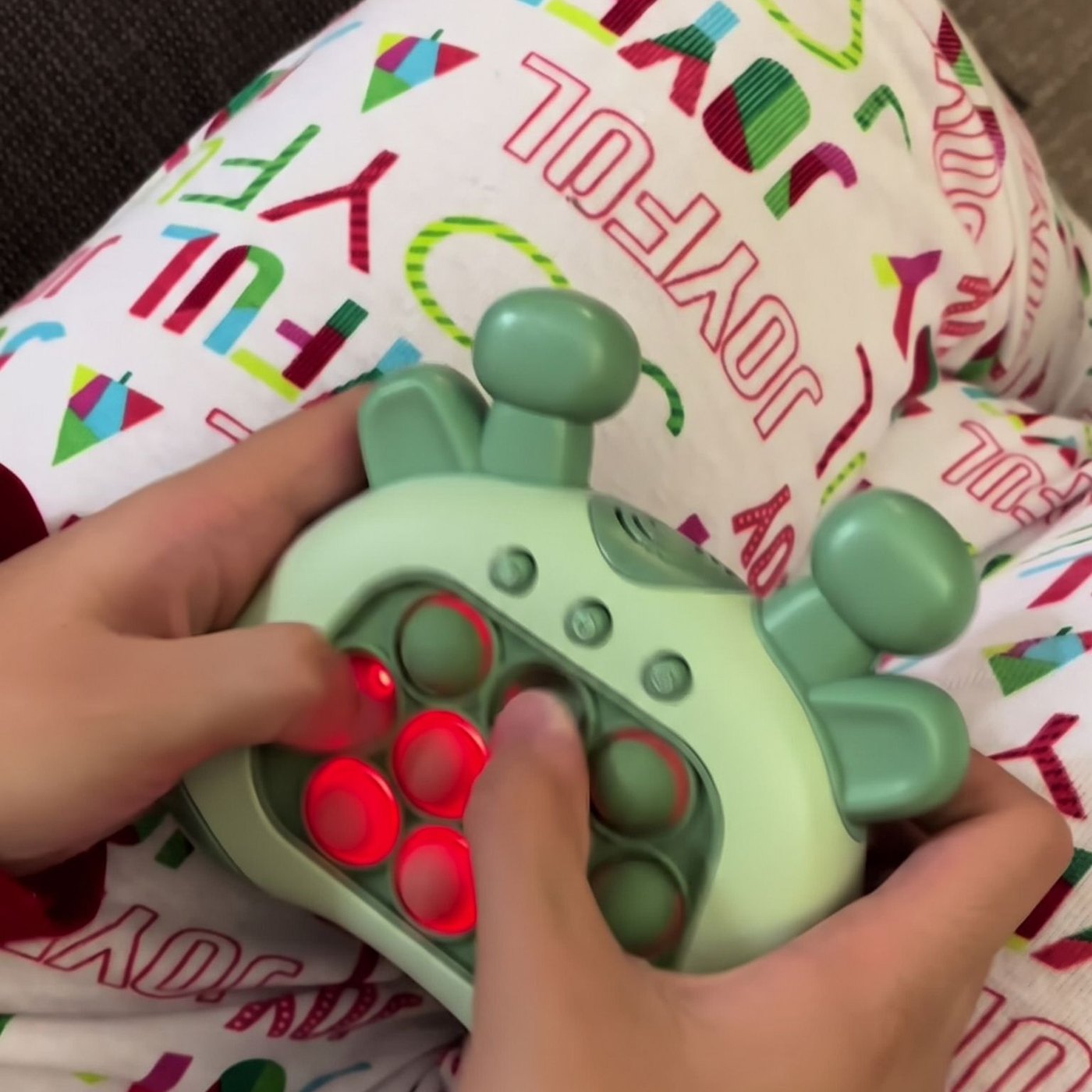 Hands pressing lit bubbles on the green push game